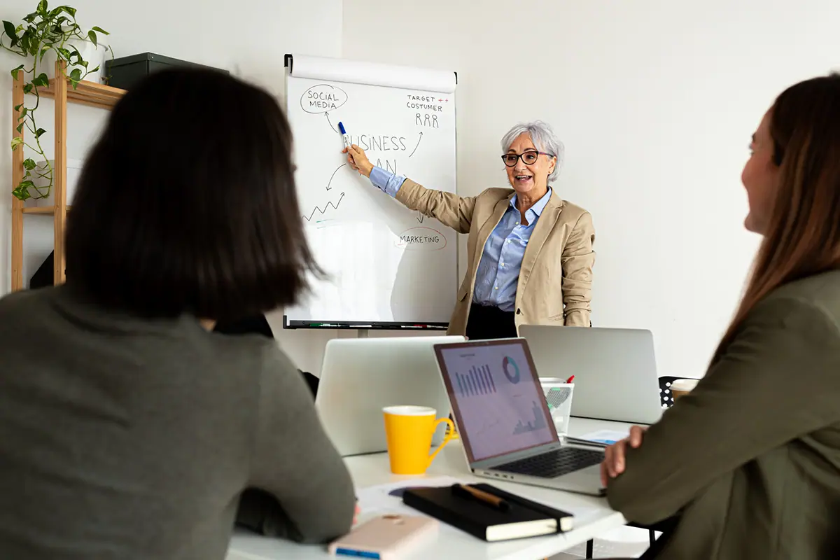 Propriétaires d'entreprise en atelier de coaching de groupe devant un tableau