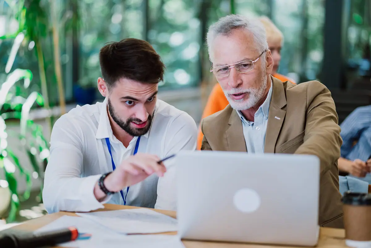 Un coach d'affaires accompagne un entrepreneur devant un ordinateur