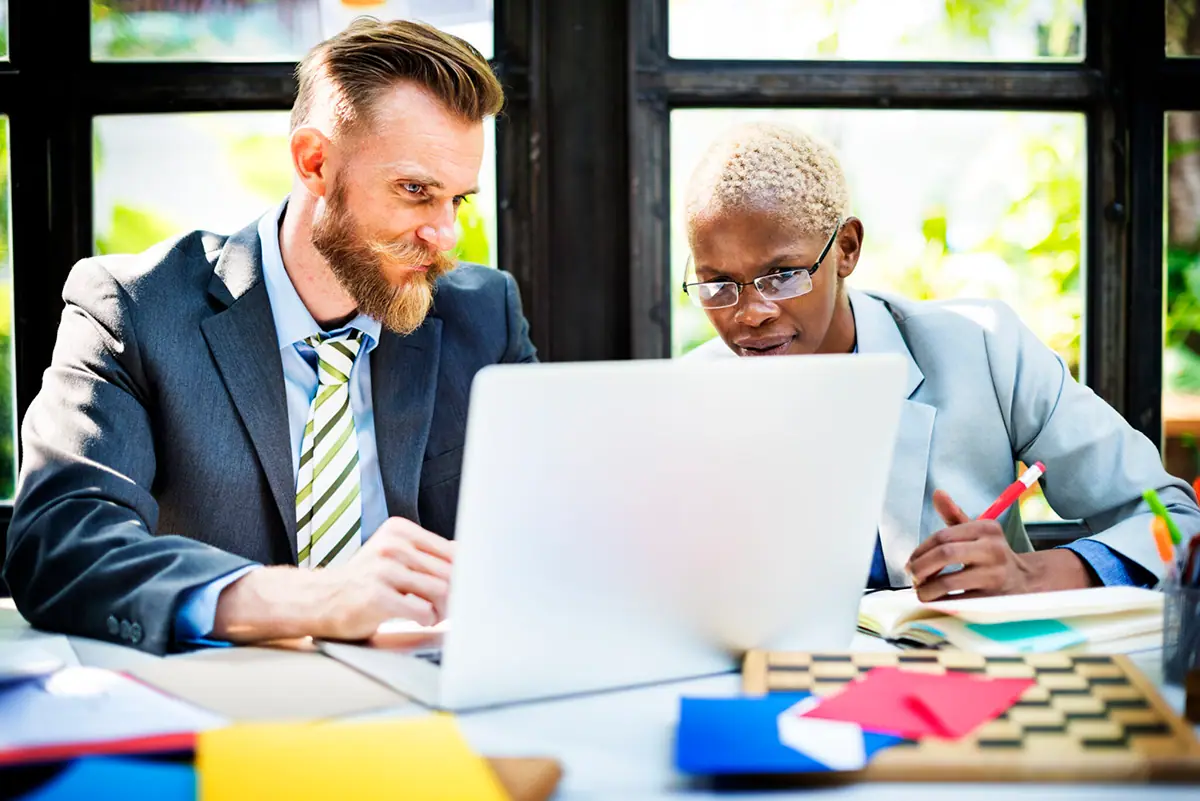 Une coach d'affaires et un entrepreneur travaillent ensemble sur un plan